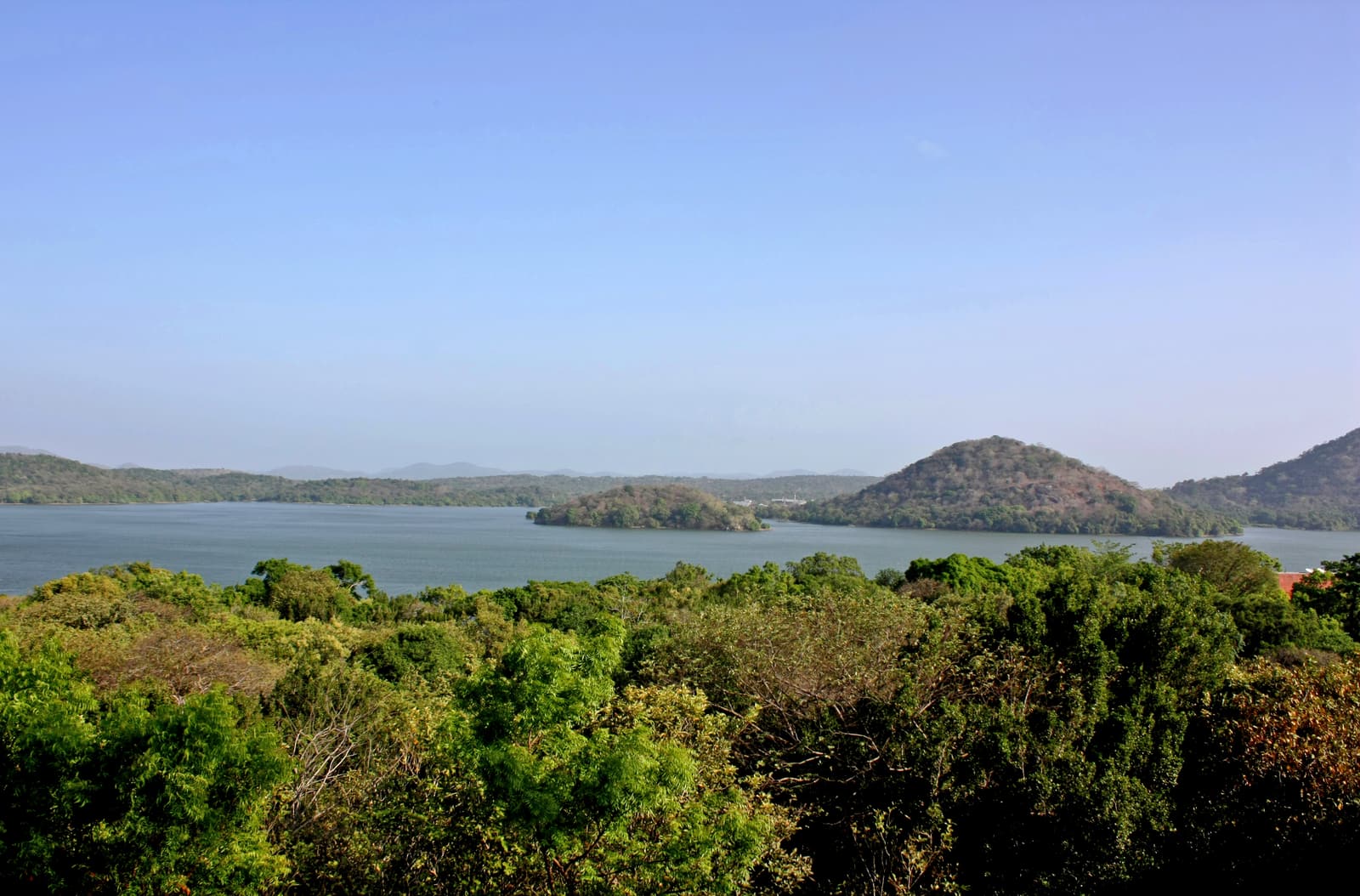 Der blaue Giritale-Stausee mit bewaldeten Hügeln und Inseln